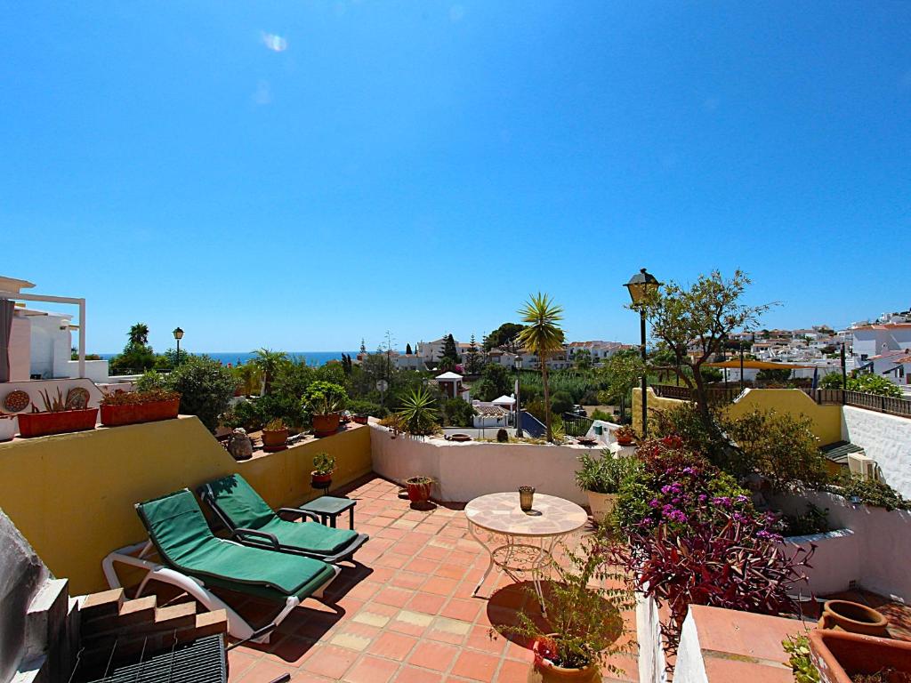 patio z krzesłami i stołem na balkonie w obiekcie Casablanca Villas w mieście Nerja