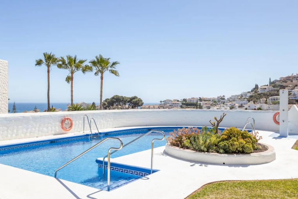 basen z widokiem na ocean i palmy w obiekcie Casablanca Villas w mieście Nerja