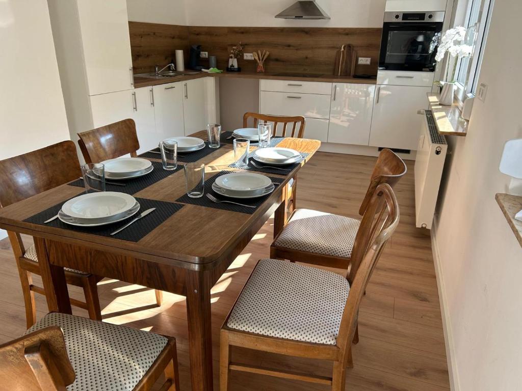 Una mesa de comedor con sillas y una cocina. en WALDnah Rückzugsort in Haiterbach, en Haiterbach
