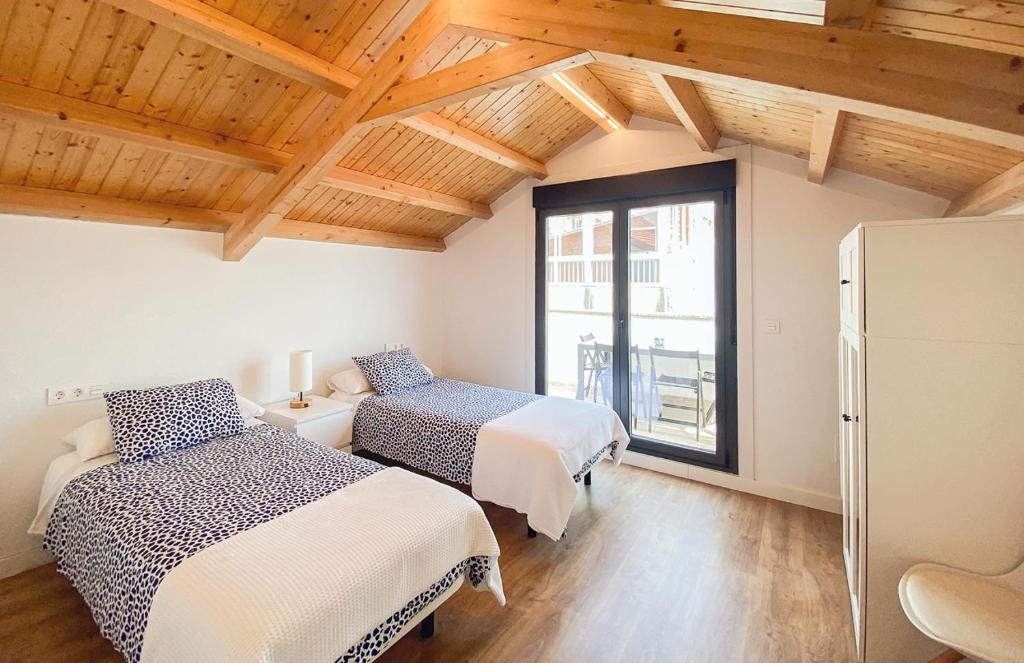a bedroom with two beds and a large window at SOCAIRO in Cangas de Morrazo