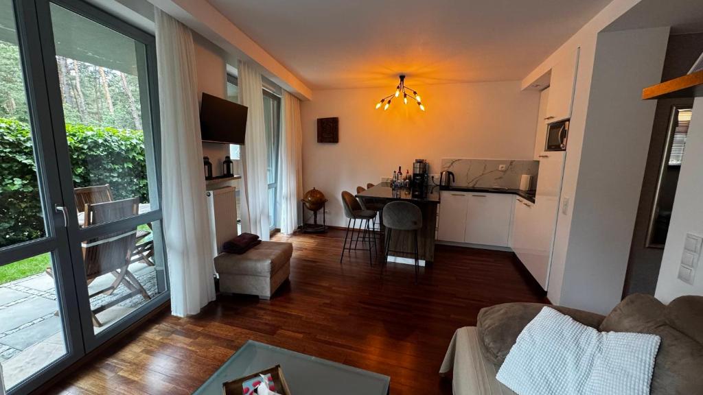 a living room with a couch and a kitchen with a table at Apartament Willa Woda in Jurata