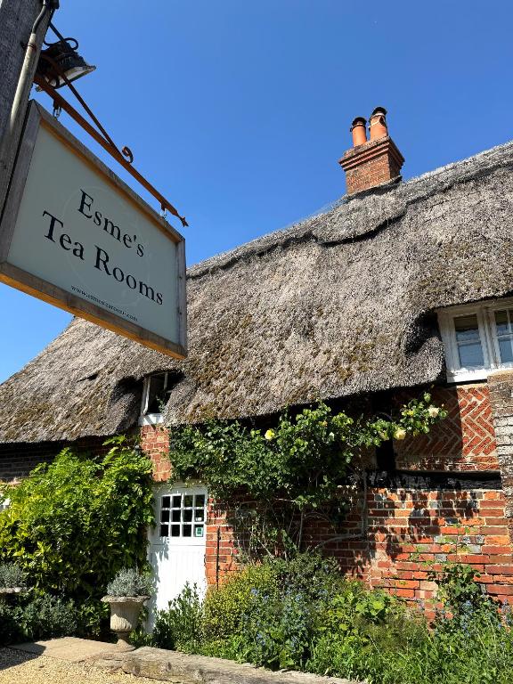 an old brick building with a thatched roof at Thatched Cottage Hotel in Brockenhurst