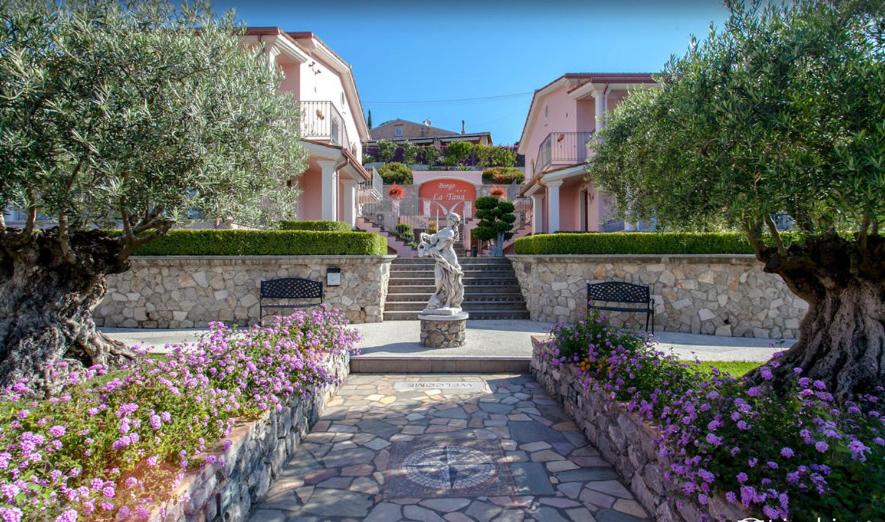 a garden with flowers and a statue in a building at Hotel Ristorante Borgo La Tana in Maratea