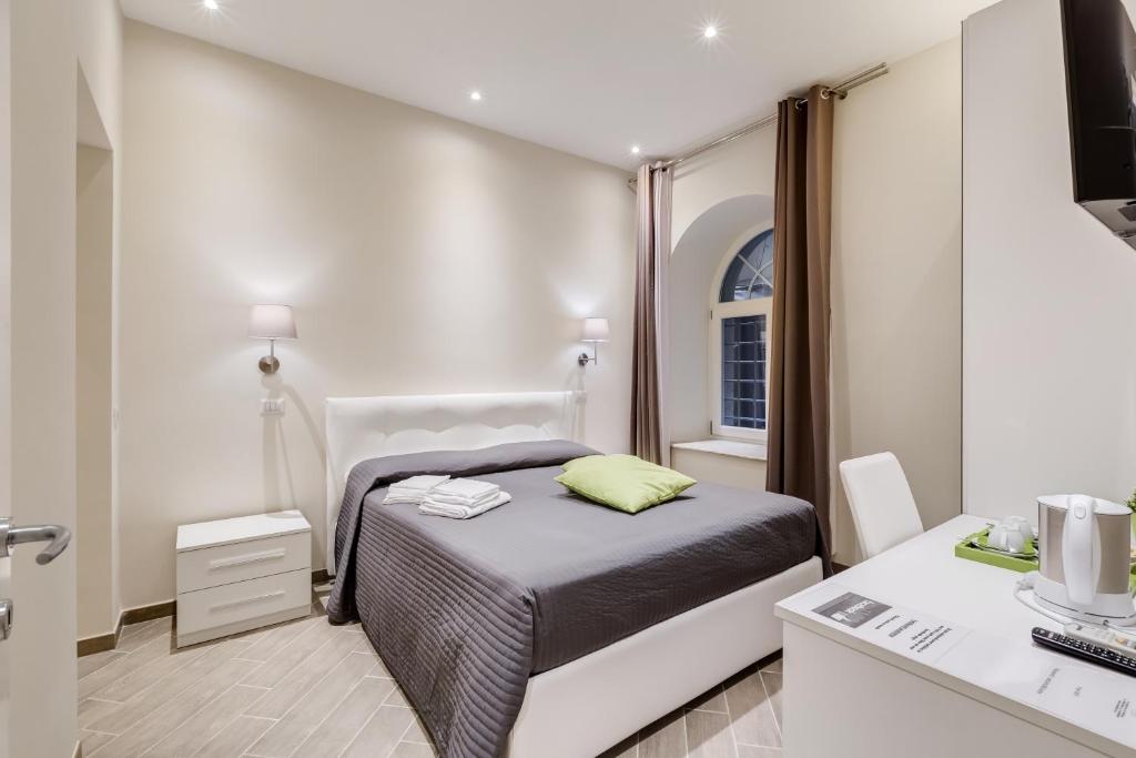 a small bedroom with a bed and a desk at Vaticano 38 Suites in Rome