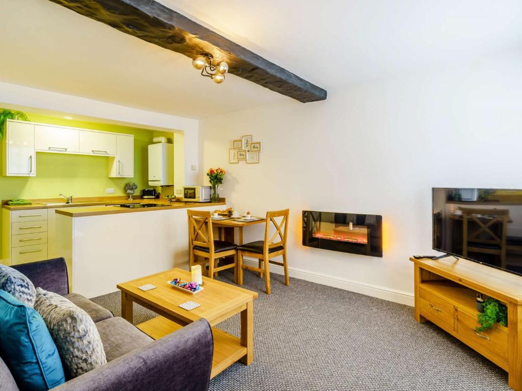 Una sala de estar con un sofá y una mesa y una cocina. en 2 Bed in Cockermouth 85514, en Cockermouth