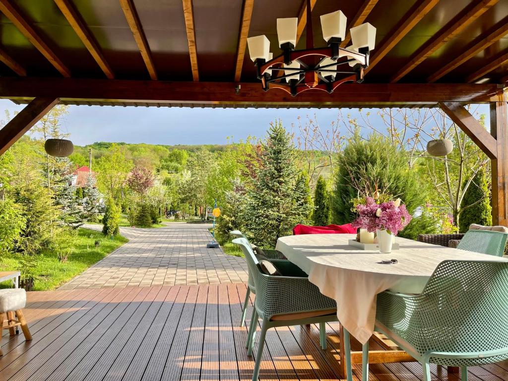 a patio with a table and chairs on a deck at domeniul la moșie caianu in Căianu