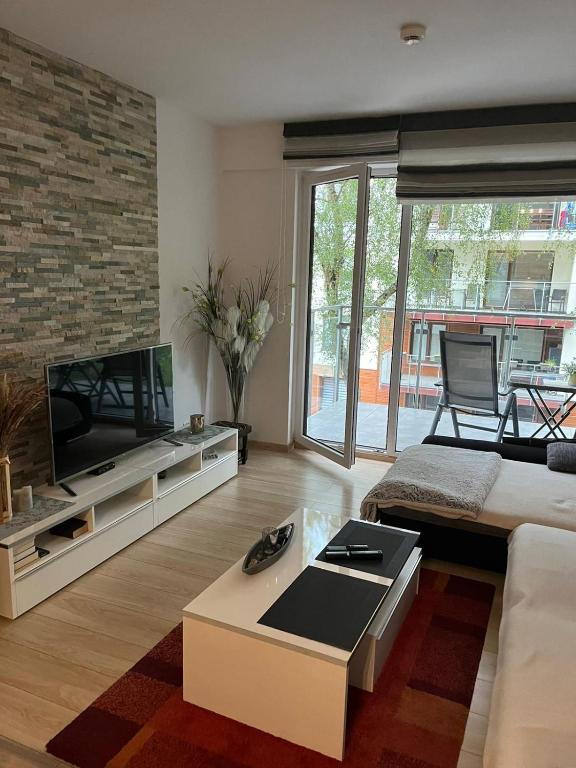a living room with a couch and a flat screen tv at Apartament Polanki E207 in Kołobrzeg