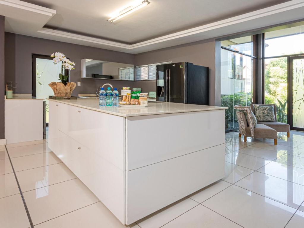 a kitchen with a white island in a room at Corals 4, Zimbali Estate by Euphoric Leisure in Ballito