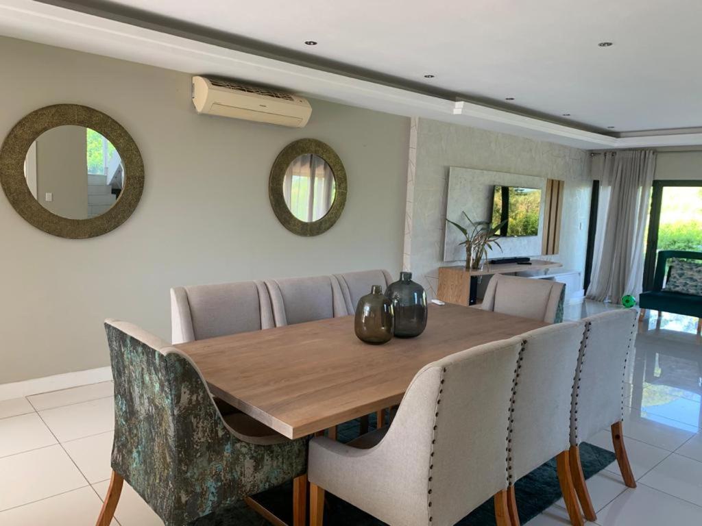 a dining room with a wooden table and chairs at Corals 4, Zimbali Estate by Euphoric Leisure in Ballito