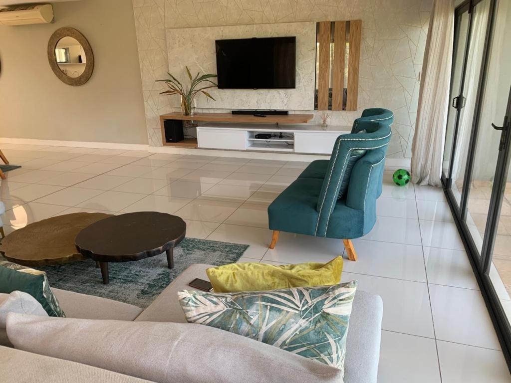 a living room with a couch and a tv at Corals 4, Zimbali Estate by Euphoric Leisure in Ballito