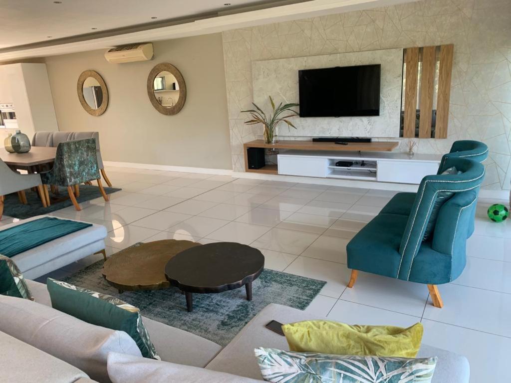 a living room with a couch and a tv at Corals 4, Zimbali Estate by Euphoric Leisure in Ballito
