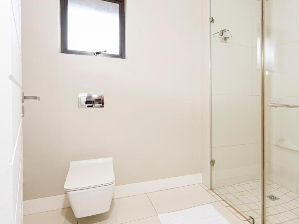 a bathroom with a toilet and a shower at Corals 4, Zimbali Estate by Euphoric Leisure in Ballito