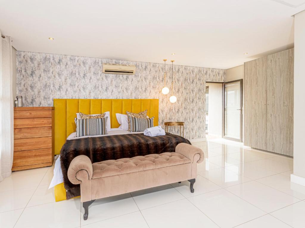 a bedroom with a large bed and a couch at Corals 4, Zimbali Estate by Euphoric Leisure in Ballito