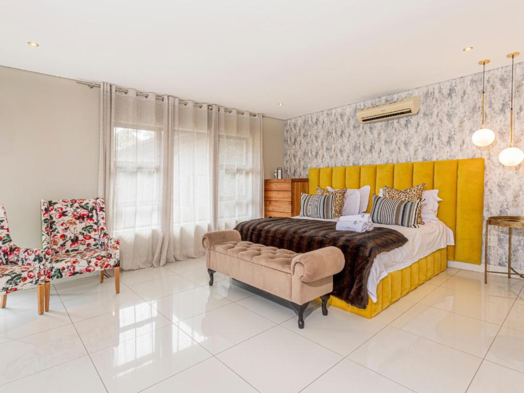 a bedroom with a large yellow bed and a chair at Corals 4, Zimbali Estate by Euphoric Leisure in Ballito