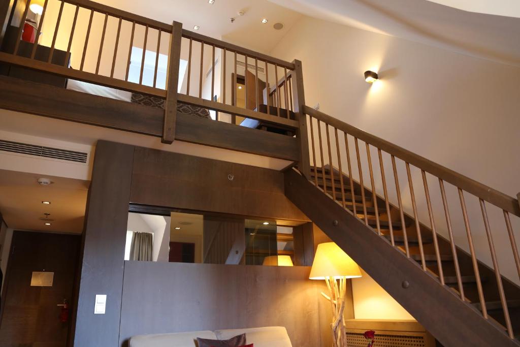 a staircase in a living room with a couch at Schlosshotel Kitzbühel A-ROSA Collection in Kitzbühel