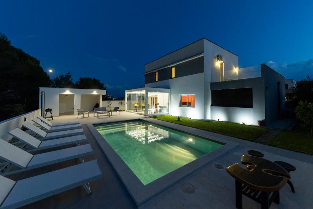 a house with a swimming pool at night at Alba Family Home in Zadar