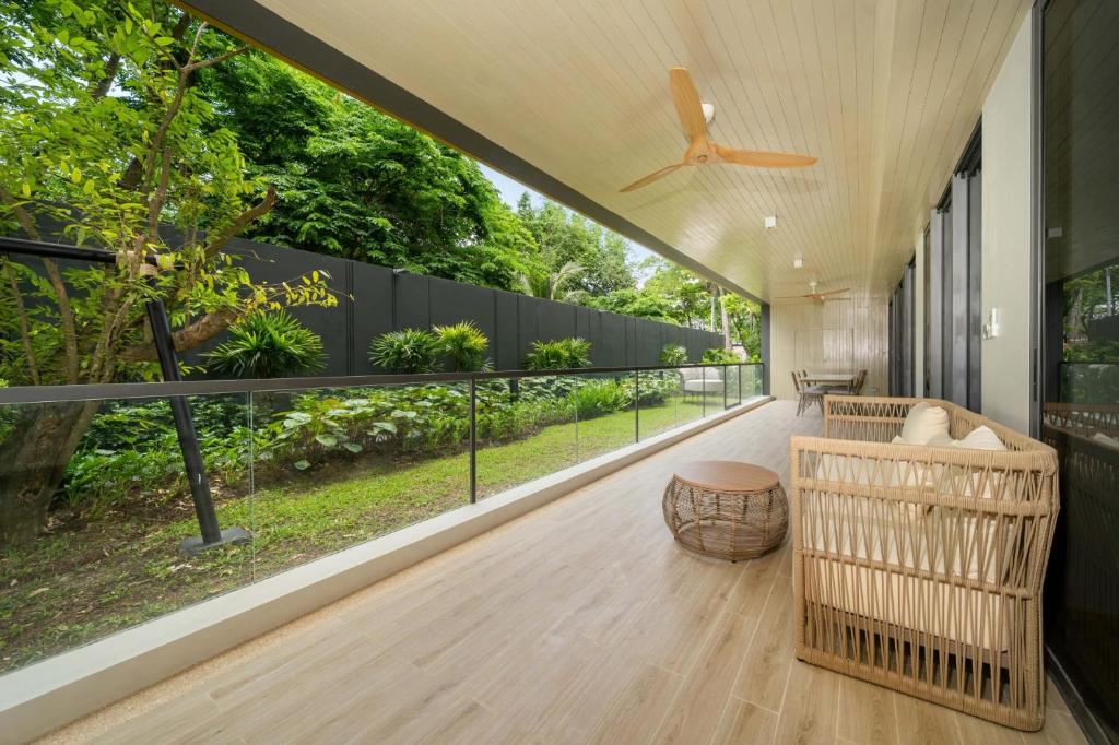 sala de estar con ventilador de techo y balcón en Apartment at Laguna Beachside by Lofty, en Bang Tao Beach