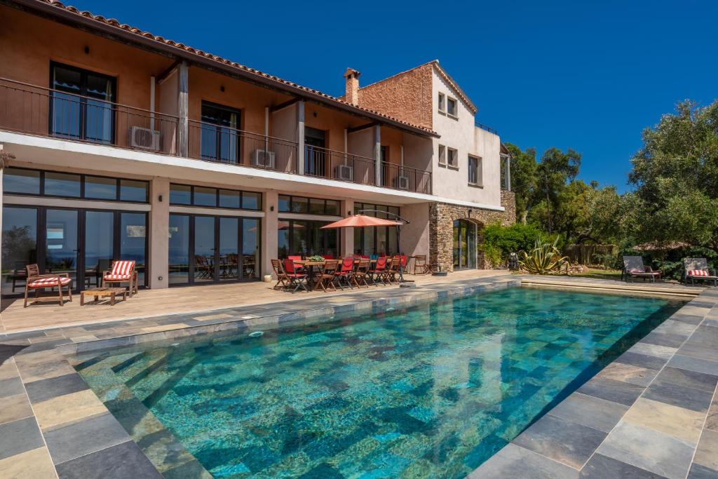 une piscine devant une maison dans l'établissement Grande Villa 750 m2 Le Mas des chênes, à Bormes-les-Mimosas