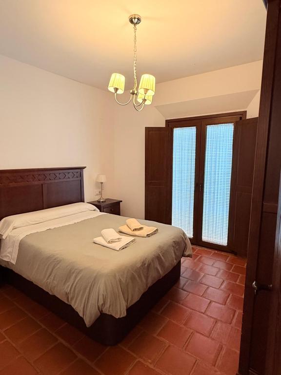 sypialnia z łóżkiem i żyrandolem w obiekcie Apartamentos Bodeguetas w mieście Constantina
