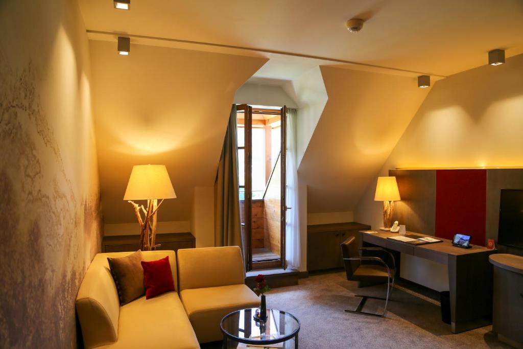a living room with a couch and a desk at Schlosshotel Kitzbühel A-ROSA Collection in Kitzbühel