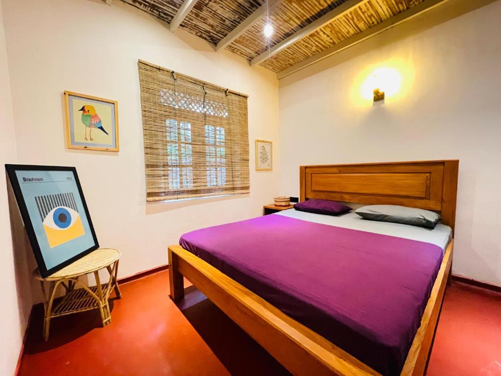 a bedroom with a bed with a purple blanket at Marisol Villa in Unawatuna