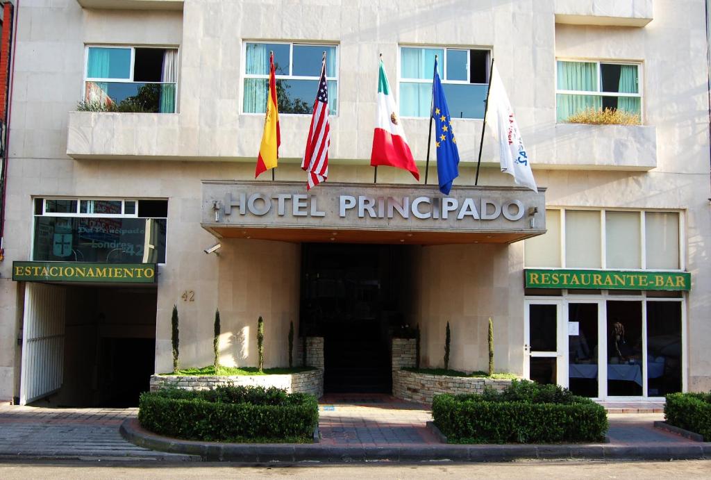 a hotel entrance with flags in front of a building at Hotel del Principado in Mexico City