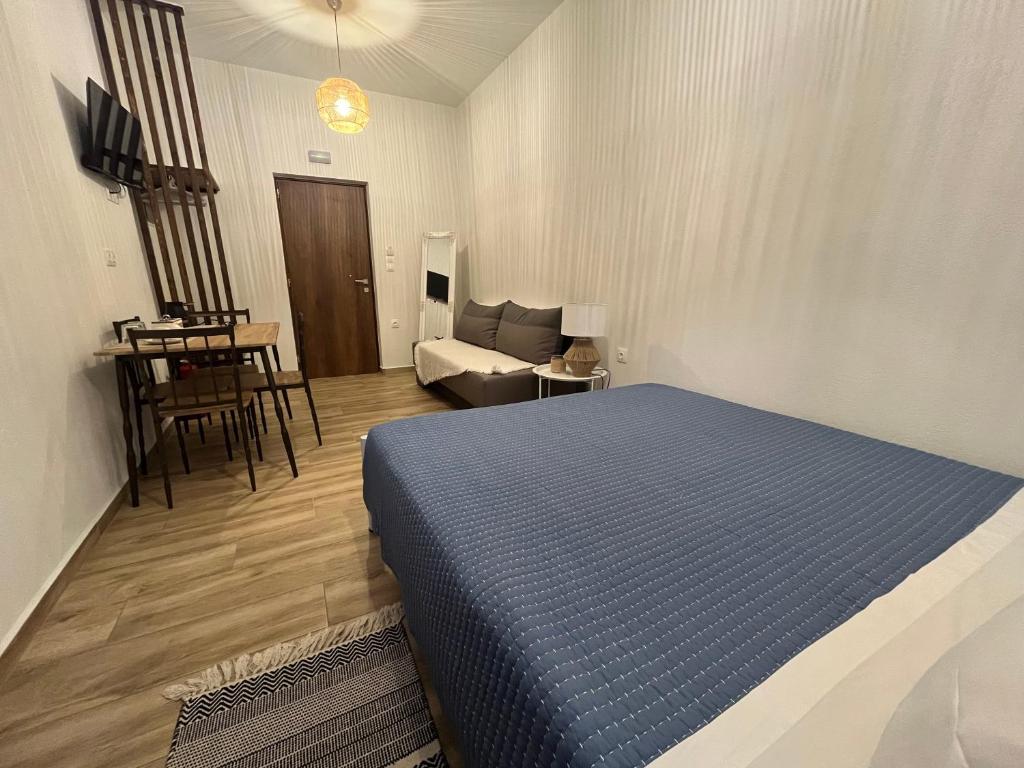a bedroom with a bed and a living room at Anemologio Fine Village Living in Ayía Kiriakí