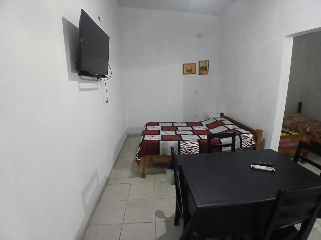 a room with two beds and a table and a television at Avenida Colon in Santiago del Estero