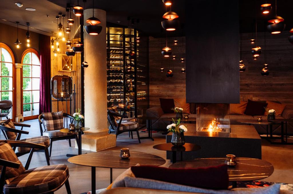 a restaurant with tables and chairs and a fireplace at Schlosshotel Kitzbühel A-ROSA Collection in Kitzbühel