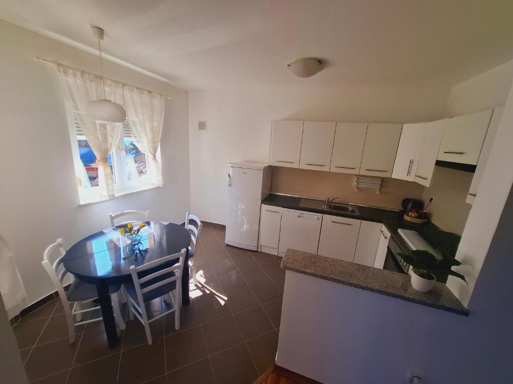a kitchen with a table and a dining room at Apartment ARIELA in Tisno