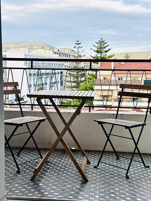 une table de pique-nique et deux chaises sur un balcon dans l'établissement Orangers Apartment, à Nice