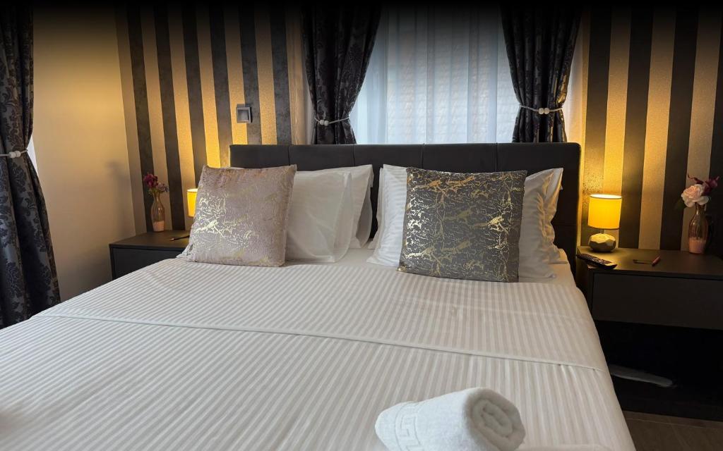 a bedroom with a bed with white sheets and pillows at Alsago Lux in Sesvete