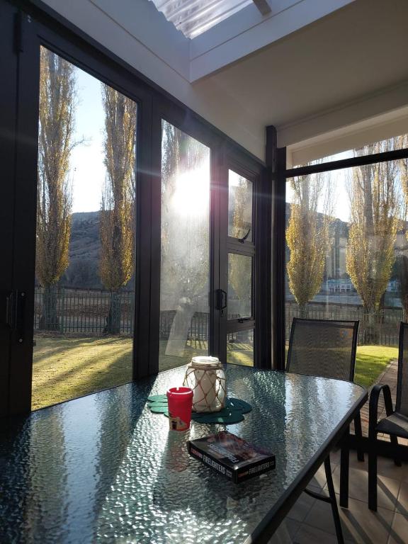 a dining room with a table and large windows at Clarens, Paddocks 23 in Clarens