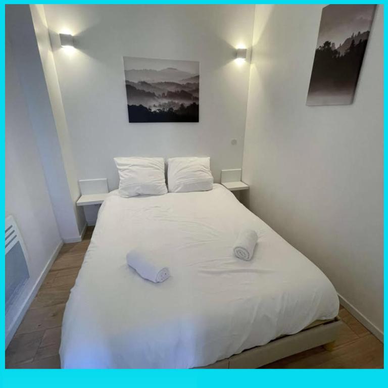 une chambre avec un lit blanc avec deux oreillers dessus dans l'établissement Location vacance en plein cœur de Montignac, à Montignac