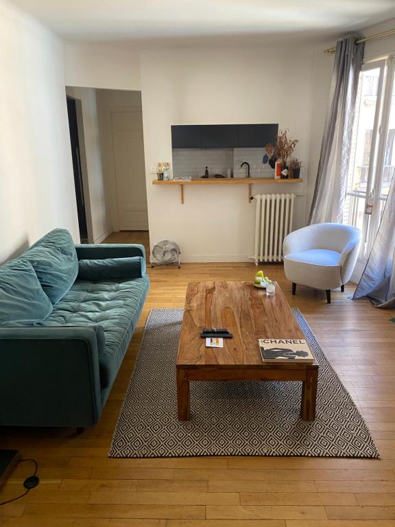 un salon avec un canapé et une table basse dans l'établissement Petit coin de paradis Paris 16, à Paris