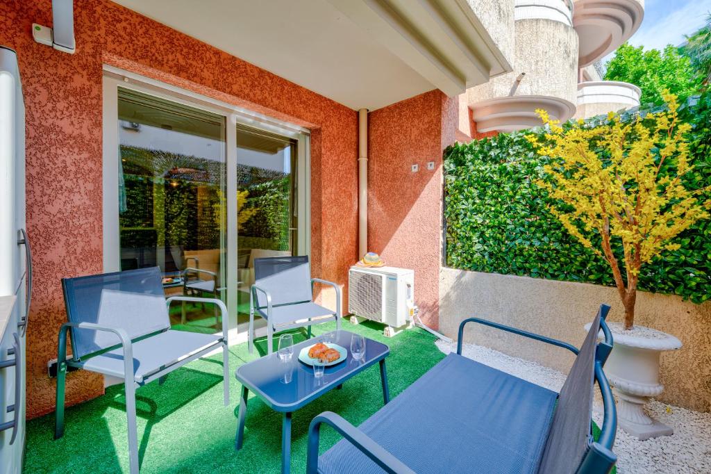 d'une terrasse avec des chaises, une table et un radiateur. dans l'établissement Studio Jardin Parking et Clim, à Nice