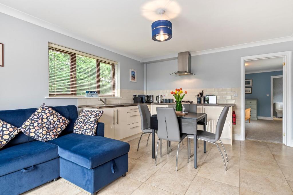a living room with a blue couch and a table at The Willows - Peaceful Retreat in Saundersfoot