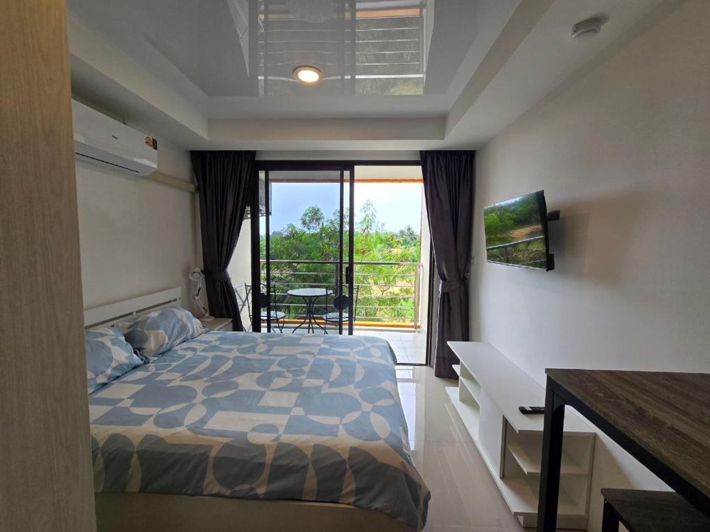 ein Schlafzimmer mit Bett und Balkon mit Aussicht in der Unterkunft 777 Beach Condotel in Mai Khao Beach