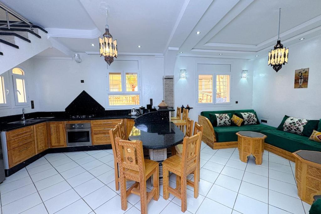 a living room with a table and a green couch at Seaside Cozy Mini Villa Stay in Id Taleb