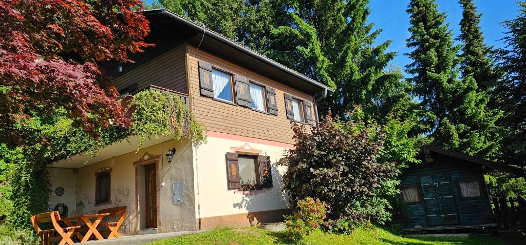 a small house with a porch and trees at Ferienhaus Anna in Weitenbach