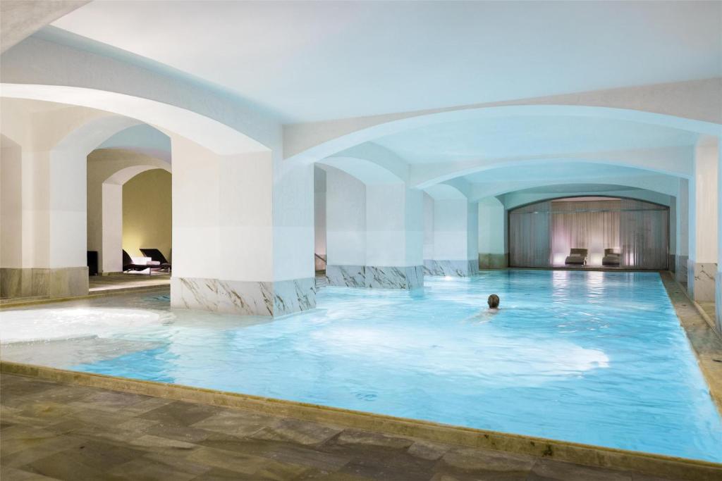 a man swimming in a pool in a hotel room at NH Collection Prague Carlo IV in Prague