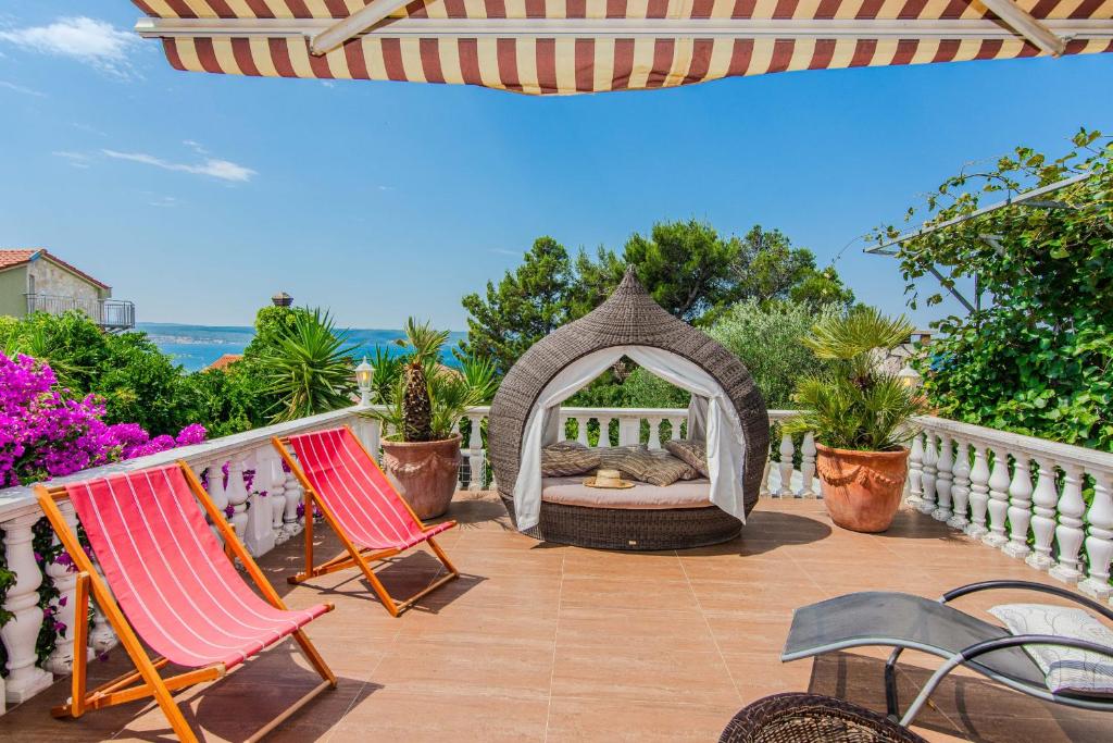 a patio with two chairs and a gazebo at Rustical Vila VERDE with traditional Tavern & Pool in Jasenice
