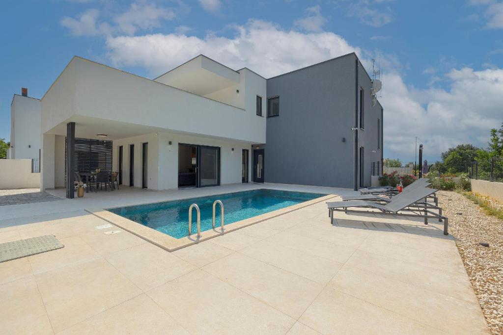 a house with a swimming pool in front of it at Villa Laura in Ližnjan