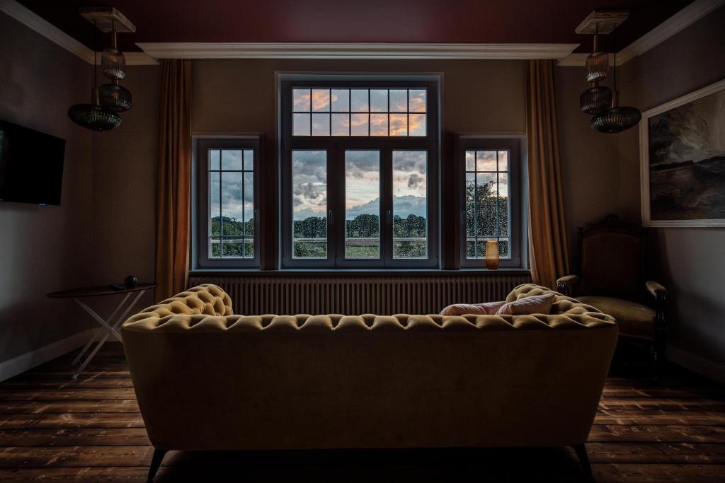 a living room with a couch in front of a window at Pärchen Auszeit am Rande der Heide Burgunder Apartment in Schwienau