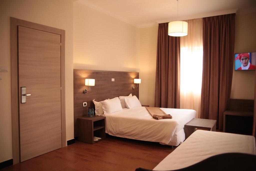 a hotel room with a bed and a window at Venetian Hotel in Addis Ababa