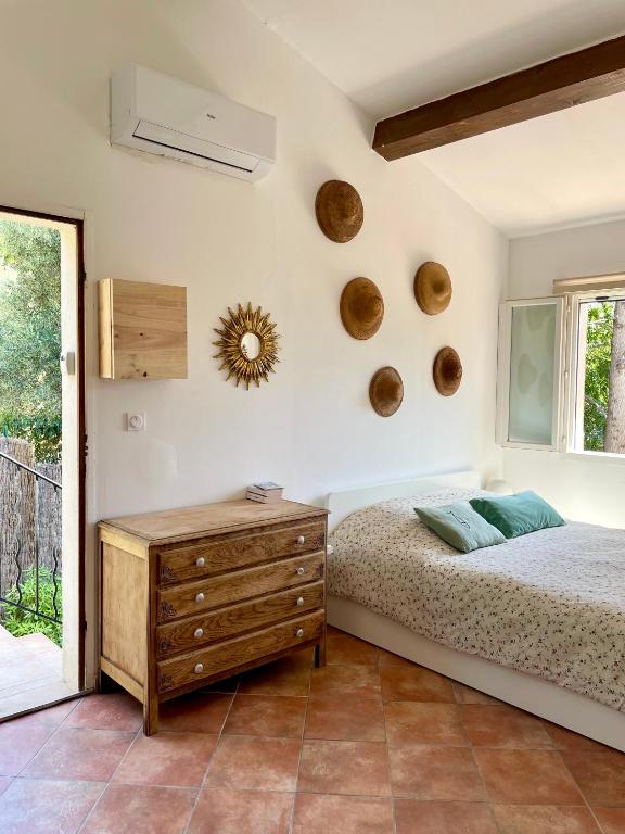 une chambre avec un lit, une commode et une fenêtre dans l'établissement Studio avec terrasse, parking et clim à 10 min à pied du vieux port, à La Ciotat