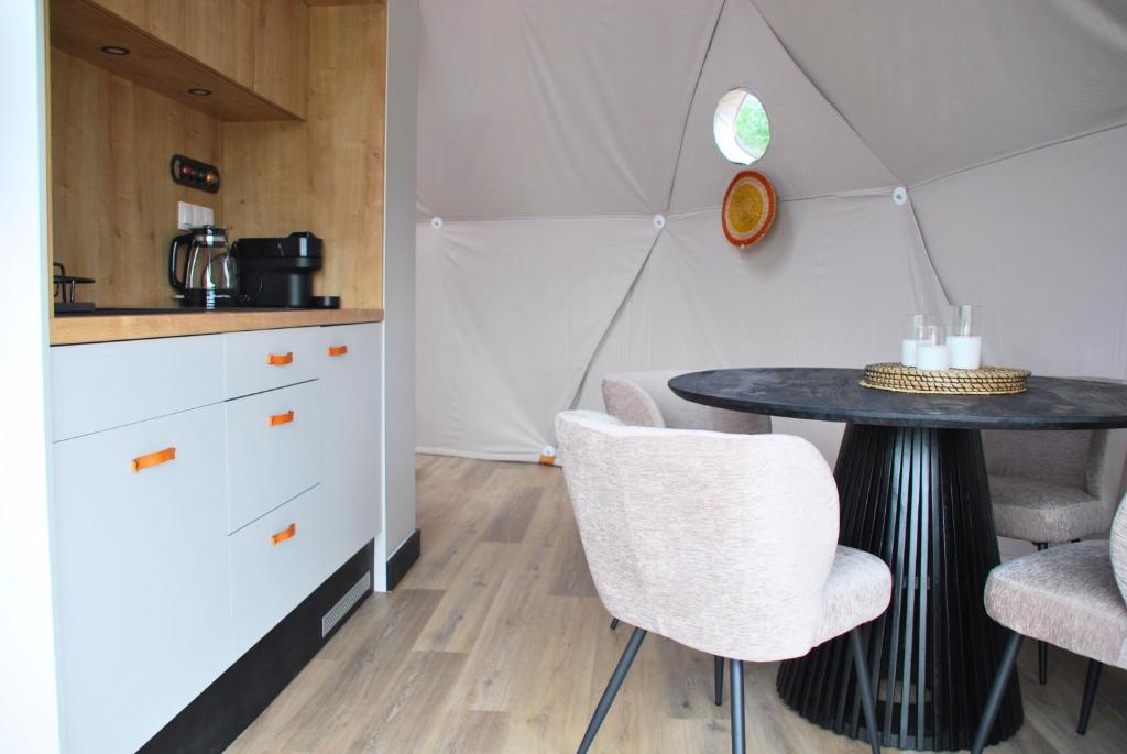 Una cocina con una mesa y sillas en una habitación. en Kilima Retreats, en West Quantoxhead