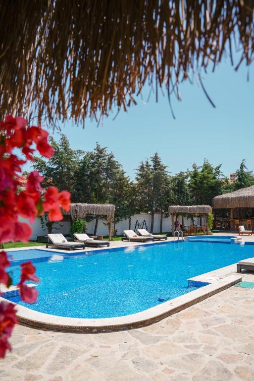 a swimming pool with chaise lounges in a resort at Albeon Luxury Hotel - Alacatı in Alaçatı