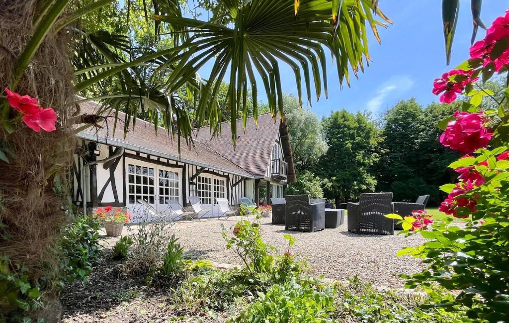une maison avec un groupe de chaises devant elle dans l'établissement Le Clos Vildor, maison de charme bordée par la rivière, à Canehan