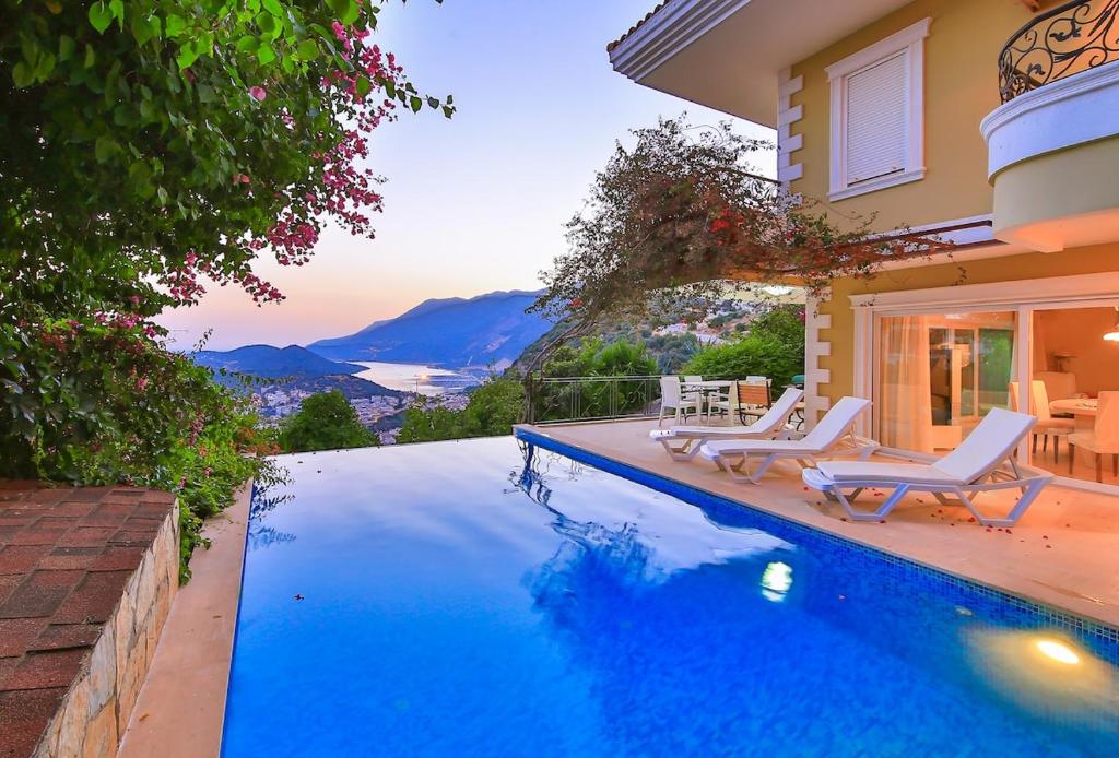 una piscina con sillas y una casa en Villa Noyan, en Kas